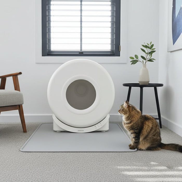 Modern interior with a smart automatic litter box placed on a carpeted floor, positioned next to a sleek black entertainment unit and dark window shutters